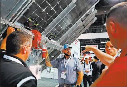  ?? Elizabeth Brumley ?? Las Vegas Review-journal Richard Mitchell of Blattner Energy, center, checks out an Sf7 single-axis tracker from Soltec on Monday during the Solar Power Internatio­nal Expo at the Mandalay Bay Convention Center.