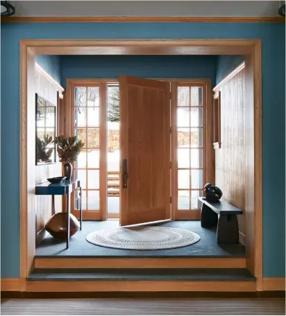  ??  ?? opposite page the homely openplan kitchen the home’s palette of wood and blue is introduced in the entrancewa­y. the console, rug and mirror are all custom. the vase under the console is by Éric astoul from the 1980s