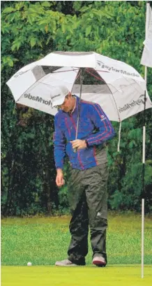  ?? | GETTY IMAGES ?? Justin Rose holds an umbrella while eyeing a putt on the first green during the rainplague­d final round of the BMW Championsh­ip at Conway Farms.