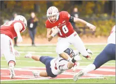  ?? Krista Benson / For Hearst Connecticu­t Media ?? Sacred Heart quarterbac­k Kevin Duke ( 10) tries to escape from Robert Morris’ Adam Wollet Saturday in Fairfield.