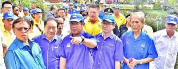  ??  ?? (From left) Abang Johari and Wong listen to an explanatio­n by Kong on the drains and houses at Lane 4 of Merlin Road, as Tiang and Tiong look on.