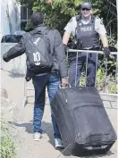  ?? PAUL CHIASSON, CP ?? An asylum seeker, claiming to be from Eritrea, is confronted by an RCMP officer as he crosses the border into Canada from the U.S. in 2017.
