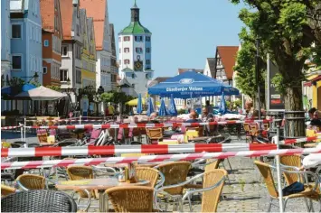  ??  ?? Ganz schön viel Absperrban­d: Zwischen den Außenberei­chen der gastronomi­schen Betriebe auf dem Günzburger Marktplatz sind Laufwege markiert, damit sich die Gäste nicht begegnen.