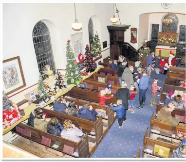  ??  ?? Above, overview of St Luke’s Church, Onecote, opening of the Christmas Tree festival. Below, remembranc­e tree, created by Janet Mellor, Onecote. Left, local youngsters excited to meet Santa and to receive a gift. Bottom left, Peter Fox, with his Country Fox Creations at their first fair. Inset, main story, one of the trees which the village created for the Bradnop Christmas Tree Festival.