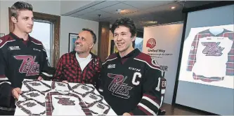  ?? CLIFFORD SKARSTEDT EXAMINER ?? Neil Morton, the 2018 United Way Petes Plaid Night chairman, chats with Peterborou­gh Petes players John Parker-Jones, left, and captain Zach Gallant on Friday at the Petes Alumni Room at the Memorial Centre while announcing details for the Petes Plaid Night taking place Thursday against the Oshawa Generals.