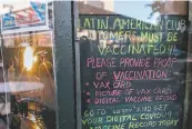  ?? Photos by Nick Otto / Special to The Chronicle ?? A sign directs patrons of the Latin American Club to show proof of vaccinatio­n. The city may require all bars and restaurant­s to follow suit.