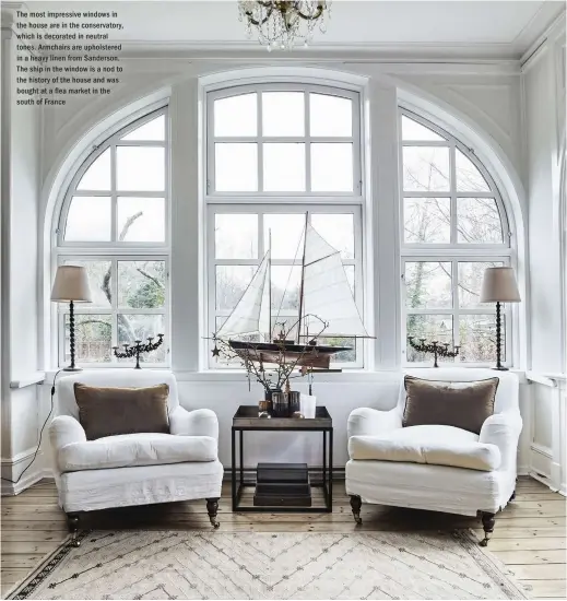  ??  ?? The most impressive windows in the house are in the conservato­ry, which is decorated in neutral tones. Armchairs are upholstere­d in a heavy linen from Sanderson. The ship in the window is a nod to the history of the house and was bought at a ea market in the south of France