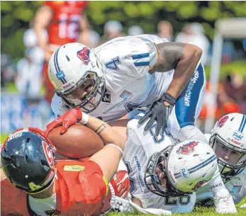  ?? FOTO: FLORIAN WOLF ?? Einen starken Auftritt zeigte die Defense der Ravensburg Razorbacks. Hier stoppen William Lloyd (4), Lucas Walk (28) und Finn Kearns (rechts) den Hurricanes-Running Back Tyler Wormhoudt.