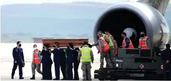  ?? — AFP photo ?? Spanish airforce personnel carry one of the three coffins with the bodies of Beriain, Fraile and Irish Young after arriving in the Torrejon de Ardoz air base.