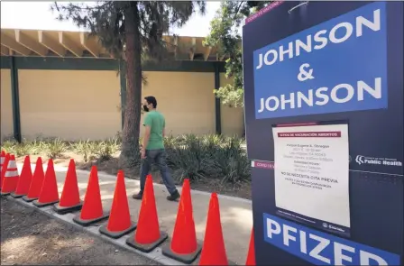  ?? DAMIAN DOVARGANES — THE ASSOCIATED PRESS FILE ?? Carlos Arrendondo arrives for his appointmen­t to get vaccinated, as banners advertise the availabili­ty of the Johnson & Johnson and Pfizer COVID-19vaccines at a county-run vaccinatio­n site July 22at the Eugene A. Obregon Park in Los Angeles.