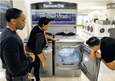  ?? Michael Macor / The Chronicle ?? Sales associates Zachary Washington (left), Sheryl Morello and Diego Carbajal work in the appliance department at the Sears store at Tanforan in San Bruno. Sears will sell its Kenmore appliances through Amazon.