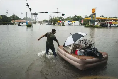  ?? Washington Post photo by Jabin Botsford ?? A resident floats his pets and belongings on an air mattress along Mercury Drive as he flees floodwater at his home in Houston on Sunday.