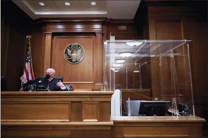  ?? MARY ALTAFFER — THE ASSOCIATED PRESS ?? U.S. District Judge P. Kevin Castel next to a witness box that is surrounded in plexiglass and contains a HEPA air filter in a Manhattan federal courtroom March. Castel said COVID-19protocol­s have become routine.