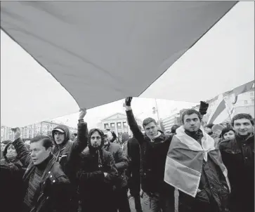  ?? Sergei Gapon
AFP/Getty Images ?? ACTIVISTS carry an opposition f lag in Minsk on the eve of Belarus’ presidenti­al election. An online game is seeking prediction­s on what percentage of the vote the government will say Alexander Lukashenko received.