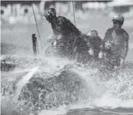  ??  ?? Emirates Team New Zealand crosses the finish line to defeat Oracle Team USA during the eighth race of the America’s Cup in Bermuda on Sunday. Gregory Bull, AP