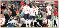  ??  ?? CONCERN England stars look on as Shaw gets treatment