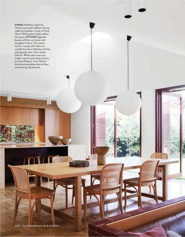  ??  ?? DINING Hoffman chairs by Thonet surround a Winter dining table from Jardan. A pair of Vitra ‘Akari 75A’ pendant lights define the space. KITCHEN Opposite
Jacqui with her son Isaac and daughter Chiara. The island bench is made with Valencia marble from Euro Marble and has a burgundy inset. Osso stools, District. White oak crown-cut timber-veneer and rattan joinery by Finch Projects. Inax ‘Patina’ brick-look porcelain tiles on floor and skirting, Artedomus.