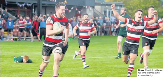  ??  ?? Grins Ruairidh Leishman has time to smile as he scores a late try