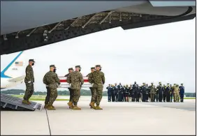  ?? DOUG MILLS / THE NEW YORK TIMES ?? President Joe Biden, Defense Secretary Lloyd Austin and others look on Aug. 29 as the body of a member of the military killed in Afghanista­n arrives at Dover Air Force Base in Delaware. After two decades of combat in Afghanista­n, there are no American troops missing in action, reflecting a major shift in military priorities.