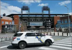  ?? MATT SLOCUM — THE ASSOCIATED PRESS FILE ?? In this March 24, 2020, file photo, a Police vehicle blocks a street near Citizens Bank Park, home of the Philadelph­ia Phillies baseball team, in Philadelph­ia. On MLB’s opening day, ballparks will be empty with the start of the season on hold because of the coronaviru­s pandemic.