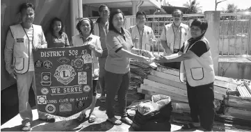  ??  ?? Centre supervisor Ting Bee Eng receives the recyclable items. Ling is at left.