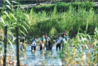  ?? CHANDAN KHANNA / AGENCE FRANCE-PRESSE ?? Migrants from South America illegally cross the Rio Grande River in Eagle Pass, Texas, at the border with Mexico on Thursday.