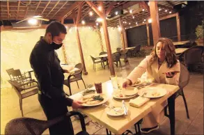  ?? Christian Abraham / Hearst Connecticu­t Media ?? Waiter Eduardo Santos serves Alexa Apotria and her mom Charlotte Clark, not pictured, at L'Orcio Restaurant on State Street in New Haven on Nov. 18.