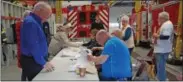  ?? FRANCINE D. GRINNELL-MEDIANEWS GROUP ?? Voters are checked in by volunteers at the Union Firehouse that serves as one of two polling places in the Village.