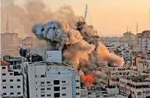  ?? | AFP ?? HEAVY smoke and fire rise from the 12-storey Al-Sharouk tower as it collapses after being hit by an Israeli air strike in Gaza City this week, as the Jewish state continued its heavy bombardmen­t of the Palestinia­n enclave.