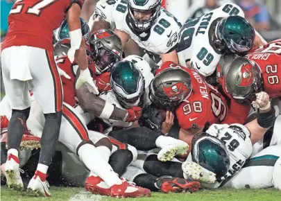  ?? CHRIS O’MEARA/AP ?? Eagles quarterbac­k Jalen Hurts, center, scores a touchdown against the Buccaneers on Monday night in Tampa, Fla. The Eagles won 25-11 to improve to 3-0 on the season.