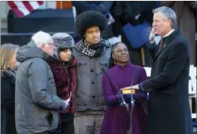  ?? THE ASSOCIATED PRESS ?? U.S. Sen. Bernie Sanders, I-Vt., left, swears in New York Mayor Bill de Blasio for a second term as mayor at City Hall in New York on Monday. With De Blasio, second from left, are his daughter Chiara, son Dante, and wife, Chirlane McCray.