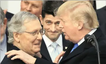  ?? PHOTO: AP ?? President Donald Trump congratula­tes Senate majority leader Mitch McConnell of Kentucky, while House speaker Paul Ryan of Wisconsin watches to acknowledg­e the final passage of tax overhaul legislatio­n by Congress at the White House on Wednesday.