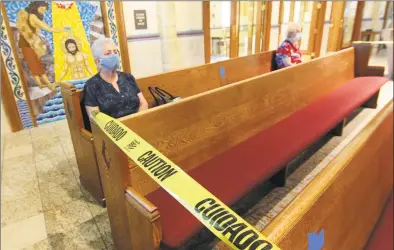  ?? Christian Abraham / Hearst Connecticu­t Media ?? Camille Marranzino, of Stratford, attends the Mass on Saturday. Caution tape is used here to stagger usable pews. Social distancing guidelines were in place and masks were mandatory.