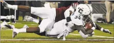  ?? Jessica Hill / Associated Press ?? UConn running back Kevin Mensah scores a touchdown as he is tackled by UMass linebacker Jarvis Miller on Saturday.