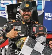  ?? STEVE HELBER/ASSOCIATED PRESS ?? Martin Truex Jr. gives a thumbs-up as he celebrates with a fan after winning a NASCAR Cup Series auto race at Martinsvil­le Speedway in Martinsvil­le, Va., Sunday.