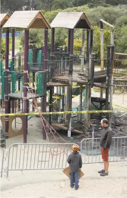  ?? Photos by Lea Suzuki / The Chronicle ?? Above: A father and son look at the play structure, apparently burned by vandalism, from the other side of a barricade. Left: A slide is now a tangle of twisted plastic after the Golden Gate Park fire.