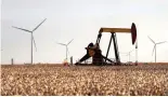  ?? Odessa American via AP, file ?? ■ In this Oct. 18, 2015, file photo, pump jacks and wind turbines are visible inside a cotton field near Lamesa, Texas. Xcel Energy has reached an agreement with cotton ginners, rural electric cooperativ­es and others as it looks for regulatory approval...