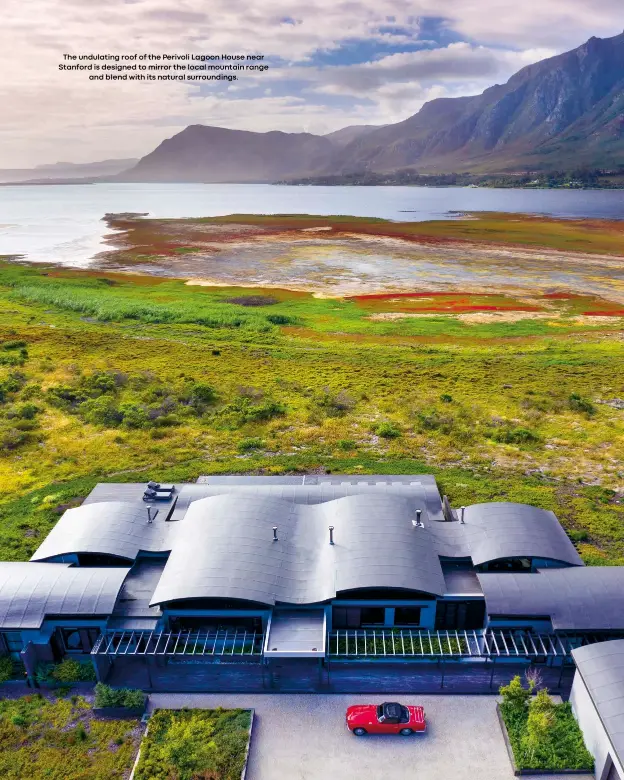  ??  ?? The undulating roof of the Perivoli Lagoon House near Stanford is designed to mirror the local mountain range
and blend with its natural surroundin­gs.