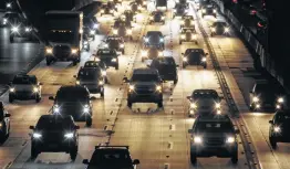  ?? Patrick T. Fallon / Bloomberg News ?? Vehicles drive in traffic down the 405 freeway at night in Inglewood, Calif. The state is suing to restore its right to set its own rules on tailpipe emissions.