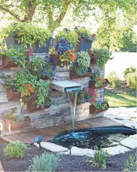  ?? JENA CARLIN ?? Jim Rude grows herbs and edible flowers on this wall in his yard in Janesville.