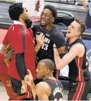  ?? WILFREDO LEE/AP ?? Heat center Bam Adebayo (13) is mobbed by teammates after he made the winning shot Sunday in Miami.