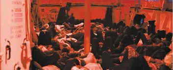  ?? PHOTO AFP ?? Exténués, des dizaines de réfugiés se reposent sur le pont du navire Aquarius.
