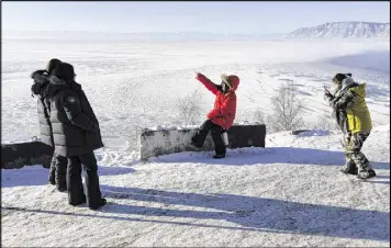  ?? JAMES HILL / THE NEW YORK TIMES ?? Chinese tourists stop to take photograph­s on the western edge of Lake Baikal. The fight to protect Lake Baikal, the world’s largest body of unfrozen fresh water, has shifted from industrial pollution to different battlegrou­nds.