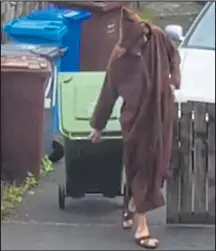  ??  ?? Abedi filmed by a neighbour putting bins out in his robe