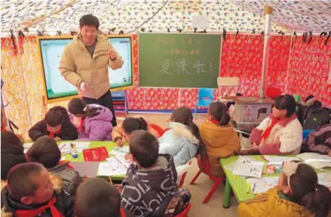  ?? ?? A teacher gives a class at a temporary classroom inside a tent in Jishishan County, northweste­rn Gansu Province, yesterday. — Xinhua