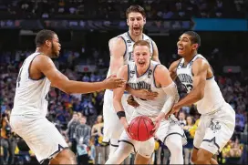  ?? TOM PENNINGTON / GETTY IMAGES ?? Donte DiVincenzo (holding ball) became the first player with a 30-point NCAA championsh­ip game since Miles Simon of Arizona in 1997.