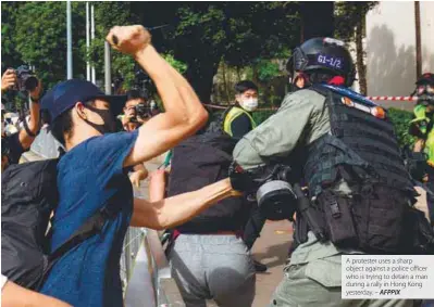 ??  ?? A protester uses a sharp object against a police officer who is trying to detain a man during a rally in Hong Kong yesterday. – AFPPIX