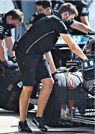  ??  ?? Final touches: The pit crew work on the Mercedes of Lewis Hamilton during practice