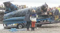  ?? Phil Noble / Associated Press ?? People watch as the wrecked Bluebird is brought to shore at Coniston Water in England’s Lake District on March 8, 2001.