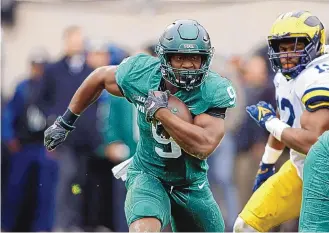  ?? AL GOLDIS/ASSOCIATED PRESS ?? Michigan State’s Kenneth Walker (9) gets past Michigan’s John Ross on his way to a chunk of his 197 yards and five touchdowns rushing. The Spartans knocked off the Wolverines 37-33.